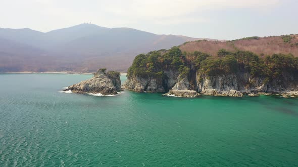 Rocky Island and a Cape in a Beautiful Bay Covered with Coniferous Trees