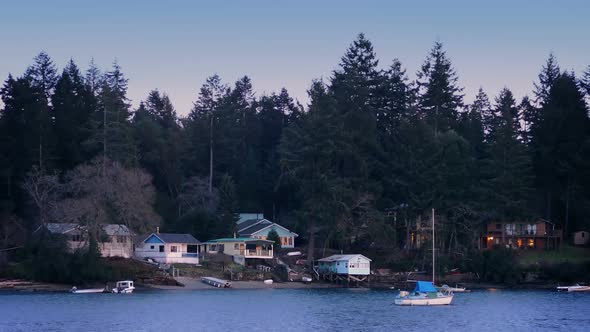 Houses And Boats By Shore At Sunset