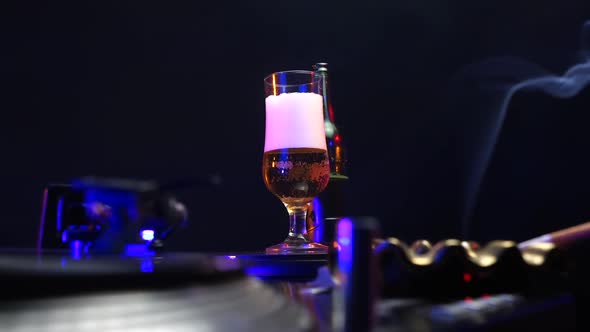 Glass of Beer Cigarette Spinning Vinyl Record and Disco Lights in 1980's Party