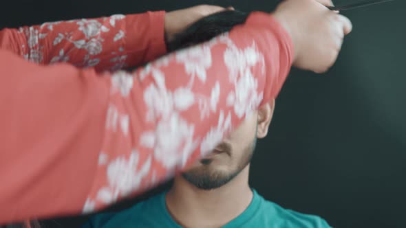 Portrait of young man in cosmetics studio and hairdresser make him a hairstyle