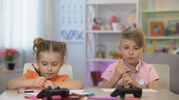 Two Children Finishing Drawing Taking Joysticks From Table, Video Game Leisure
