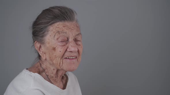 Portrait of Caucasian Senior Woman 90 Years Old with Deep Wrinkles and Gray Head Happy with Tooth