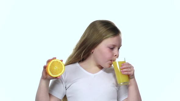 Children Holds an Orange Slice and Licks It and Drinks Orange Juice. White Background. Slow Motion