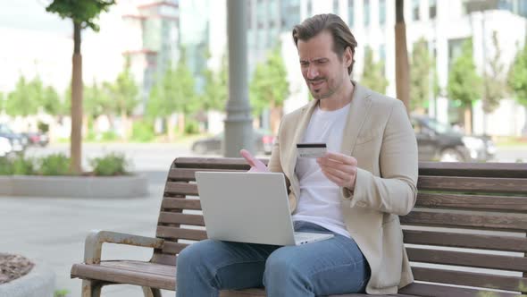 Young Man Having Online Payment Problem on Laptop Outdoor
