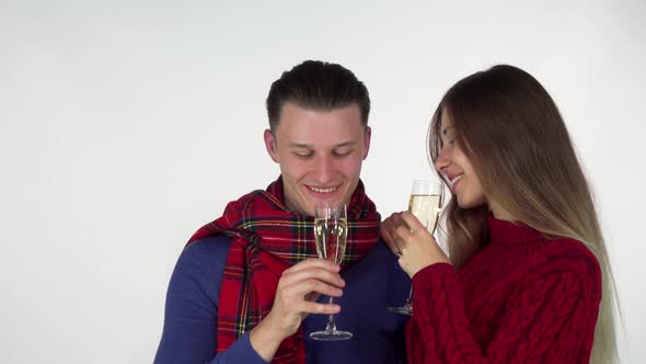 Happy Couple in Winter Clothing Celebrating Something, Clinking Champagne Glasses