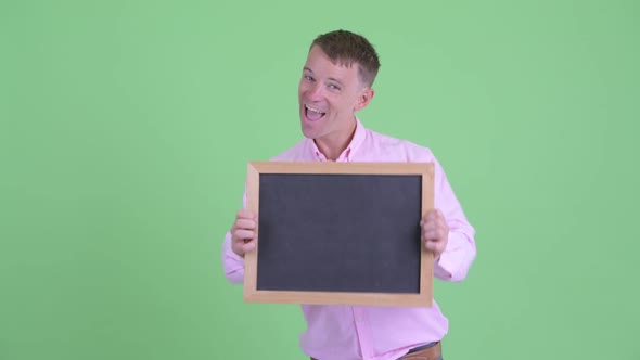 Portrait of Happy Businessman Holding Blackboard and Looking Excited