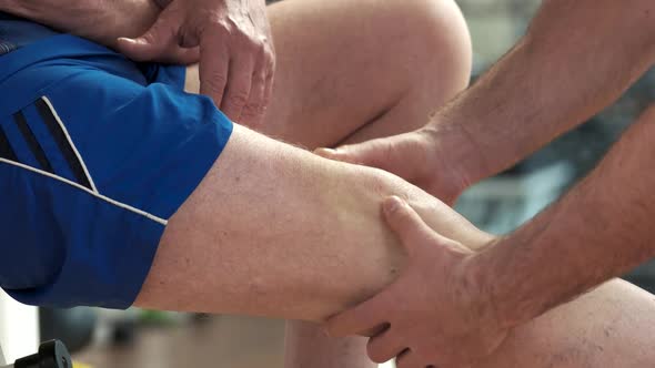 Trainer Massaging Injured Leg Close Up