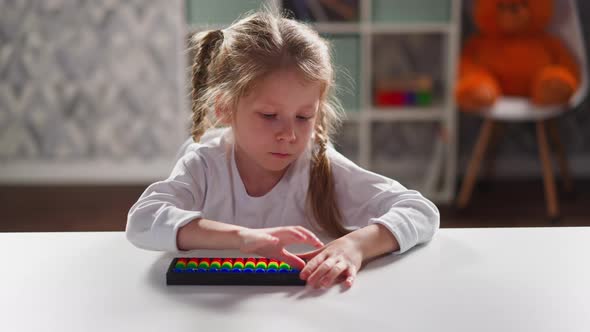 Little Girl Learns Mental Mathematics with Toy Abacus