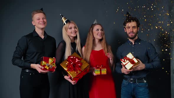Company of Beautiful People Posing with Bright Gift Boxes in Their Hands.