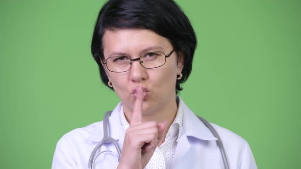 Beautiful Woman Doctor with Finger on Lips