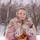 Cute girl in a traditional Russian headscarf and mittens playing on spoons on winter forest backgrou - VideoHive Item for Sale