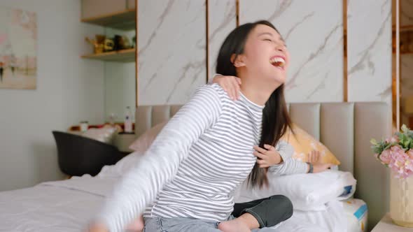 Happy asian young mother holding lifting cute little preschool child daughter up playing