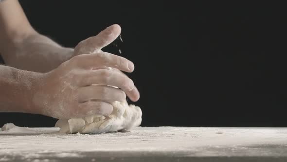 Male Hands Divide Baking Dough Into Shares on a Board Sprinkled with Flour