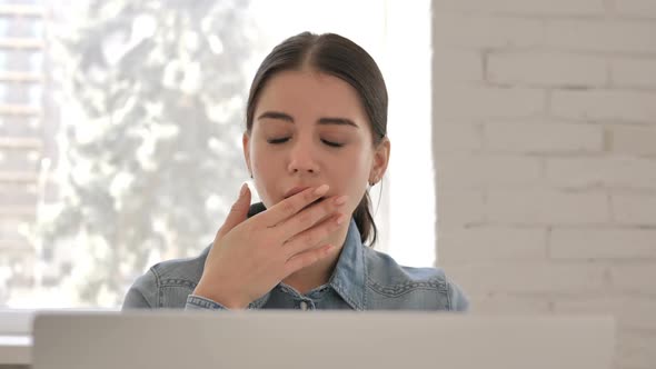 Close Up of Yawning Young Girl at Work