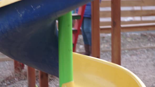 Toddler Girl Slides Down the Helical Children's Slide at Local Playground