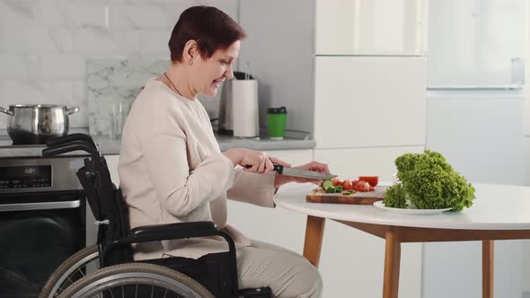 Mature Disabled Woman Cutting Vegetables in the Kitchen