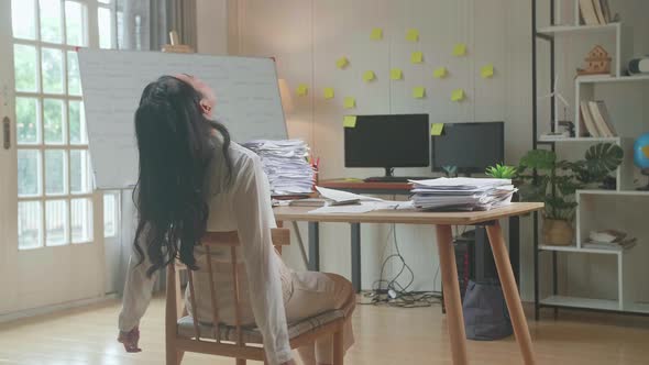 Back View Of Asian Woman Leaning On The Chair And Sleeping While Working Hard With Documents