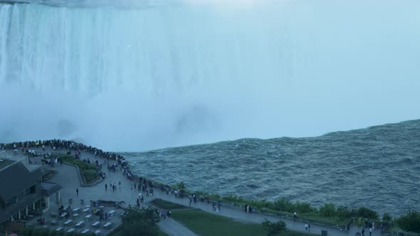 A close-up shot of people looking out over Niagara Falls from the Canadian side.