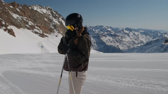 Woman Putting On Reflection Ski Visor On Ski Slope