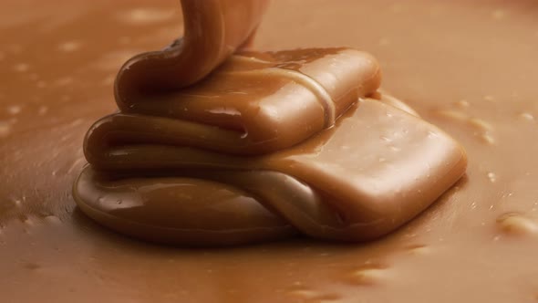 Pouring melted caramel, closeup food shot. 