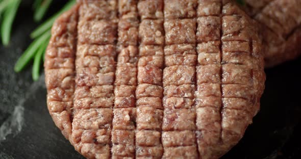 Raw Beef Burger on a Stone Board Rotates. 