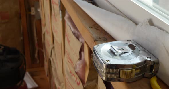 A measuring tape on the framing of a window in a new home construction site.