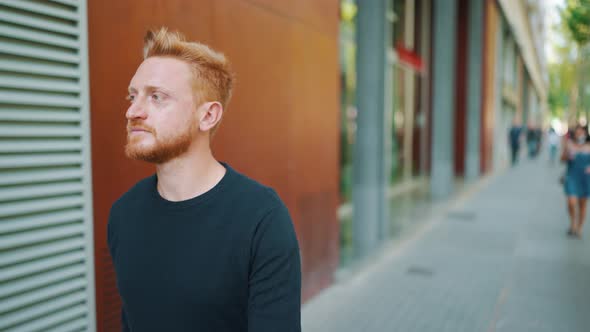 Confident red haired man walking outdoors