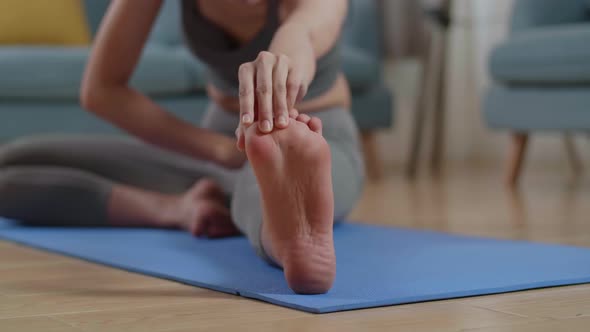 Close Up Of Hamstring Being Stretched By Athletic Female At Home