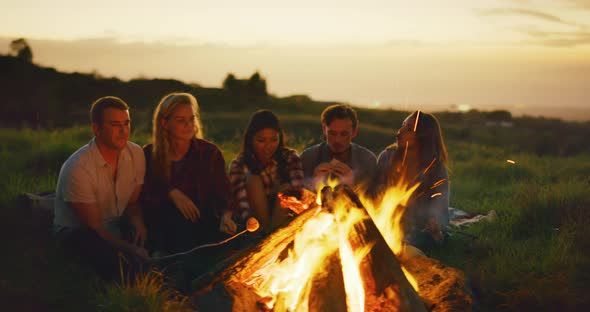 Friends Relaxing at Sunset Campfire