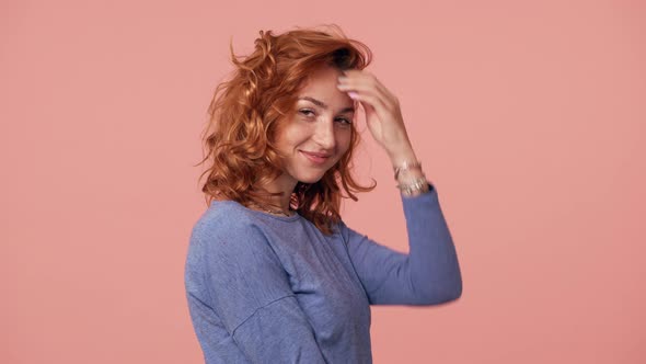 Portrait of Charming Woman 20s with Curly Red Hair Wearing Basic Shirt Posing at Camera with Smile