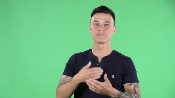 Portrait of Handsome Young Guy Is Waiting for Something Going Through and Biting His Fist. Green Screen