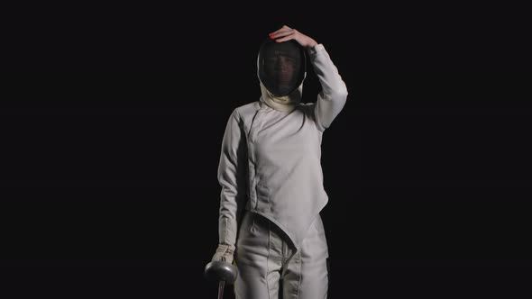 Portrait of a Professional Woman Fencing Athlete Which Puts on a Protective Mask and Becomes in a