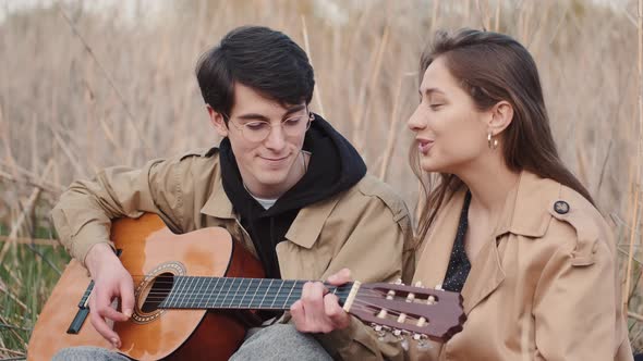 Portrait of Young Couple Having Date with Music Outdoors