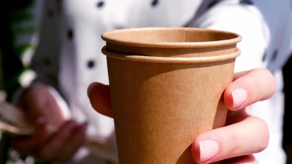 Slow Motion Female Hands Holding Wooden Forks and Paper Cups with Plates