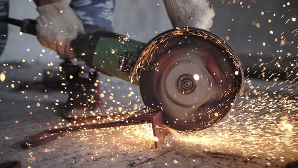 worker cuts metal with a angle grinder