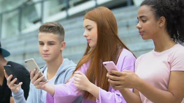 Best Friends Scrolling Social Network on Cellphones, Discussing Photo Comments