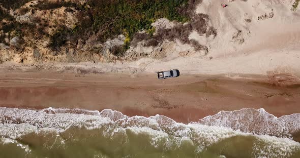Top Down View of Waves Breaking in the Sand, Flying Over Tropical Sandy Beach and Waves. Car Rides