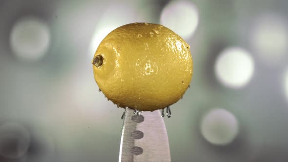 Fresh Lemon Falling Down with Water on Knife Stuck