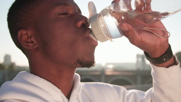 Tired Man Sipping Water After Workout