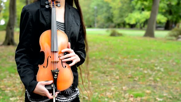 Attractive Woman with Long Hair Hug the Violin in the Forest - Breeze Blow Hair - Close Up