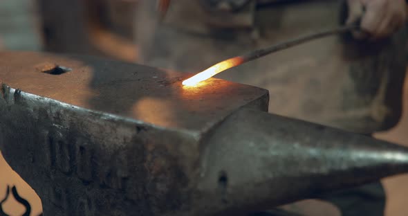 Blacksmith is Hammering a Metal Product on the Anvil