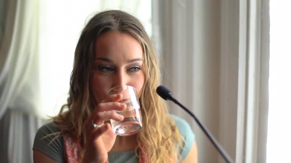 Woman Drinking Water During Interview