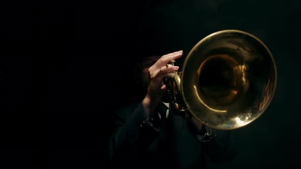 Musician in Hat and Classic Suit Plays Musical Trumpet in Studio on Black Background Closeup of