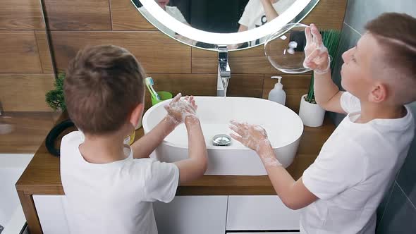 Blond Brothers Having Fun Together During Washing their Hands in the Washbasin in the Bathroom