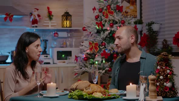 Festive Couple Giving and Receiving Gifts at Christmas Dinner