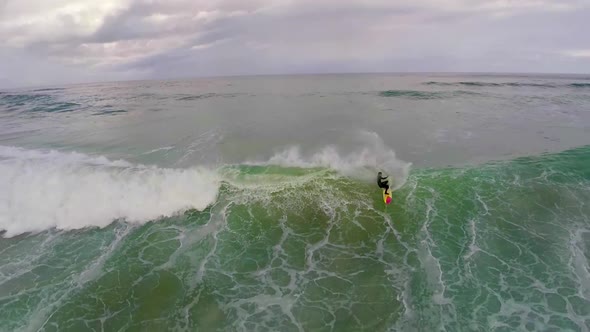 Aerial view of a surfer riding a wave while surfing