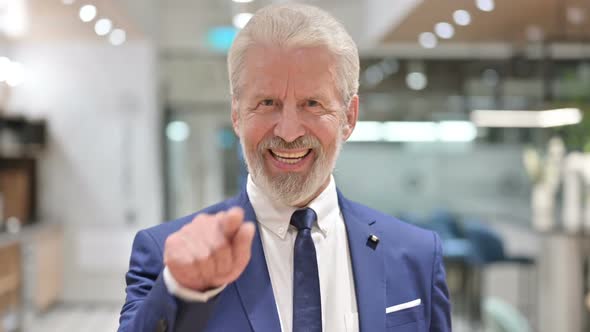 Assertive Senior Old Businessman Pointing and Inviting