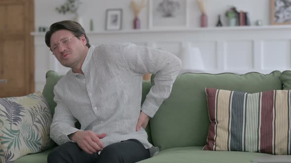 Man having Back Pain on Sofa