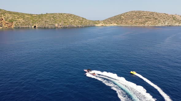 Aerial View of a Motor Boat Towing a Tube. Elounda, Crete, Greece