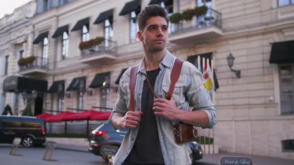 Portrait of Young Attractive Handsome Man Tourist with Backpack in City Center Slow Motion